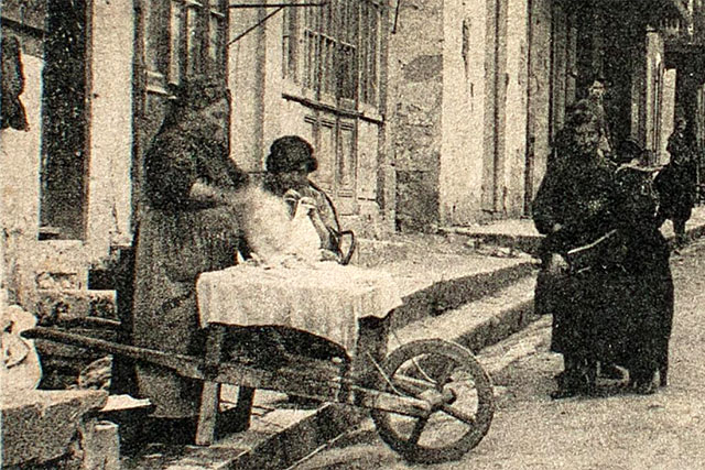 Rue du Dropt, au début des années 1900, une femme et sa brouette s'apprête pour la lessive. - | Mémoire de Villeréal, Droits réservés